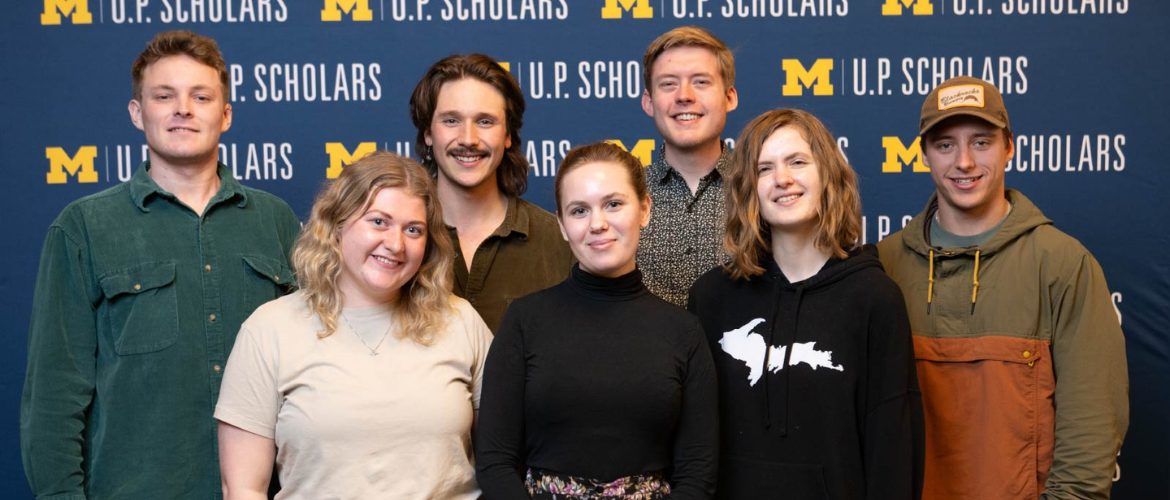 Group of UMich U.P. Scholars in front of a backdrop.